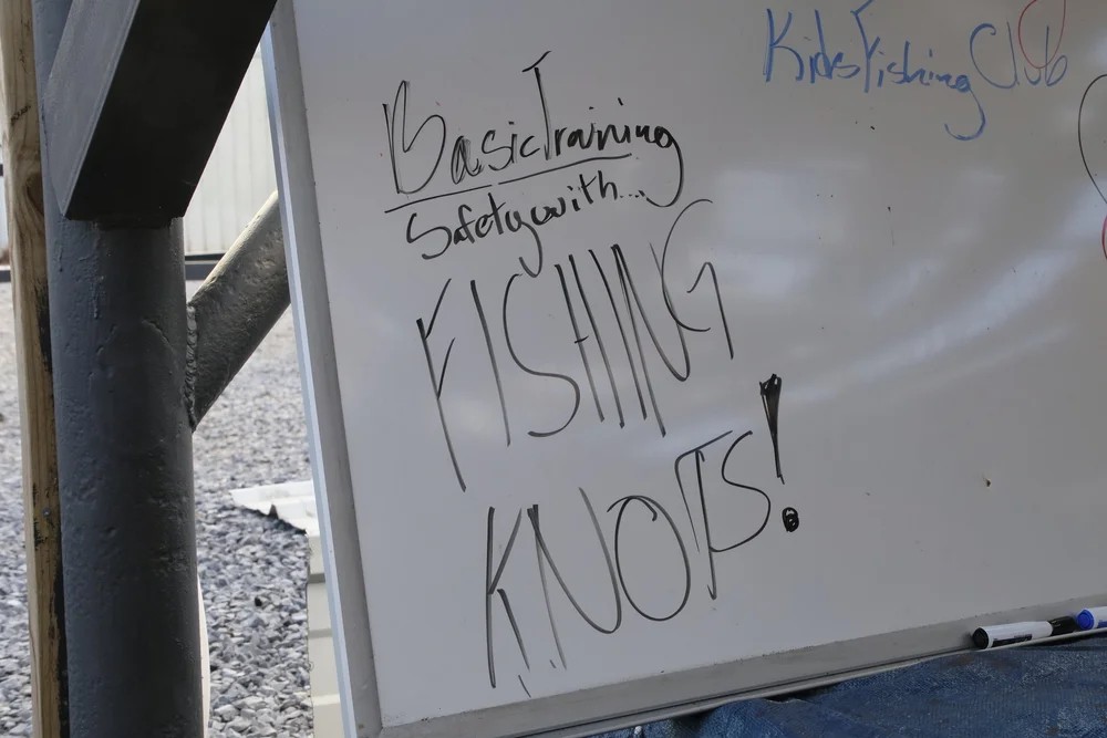 Whiteboard reading Basic Training Safety with Fishing Knots at Kids Fishing Club