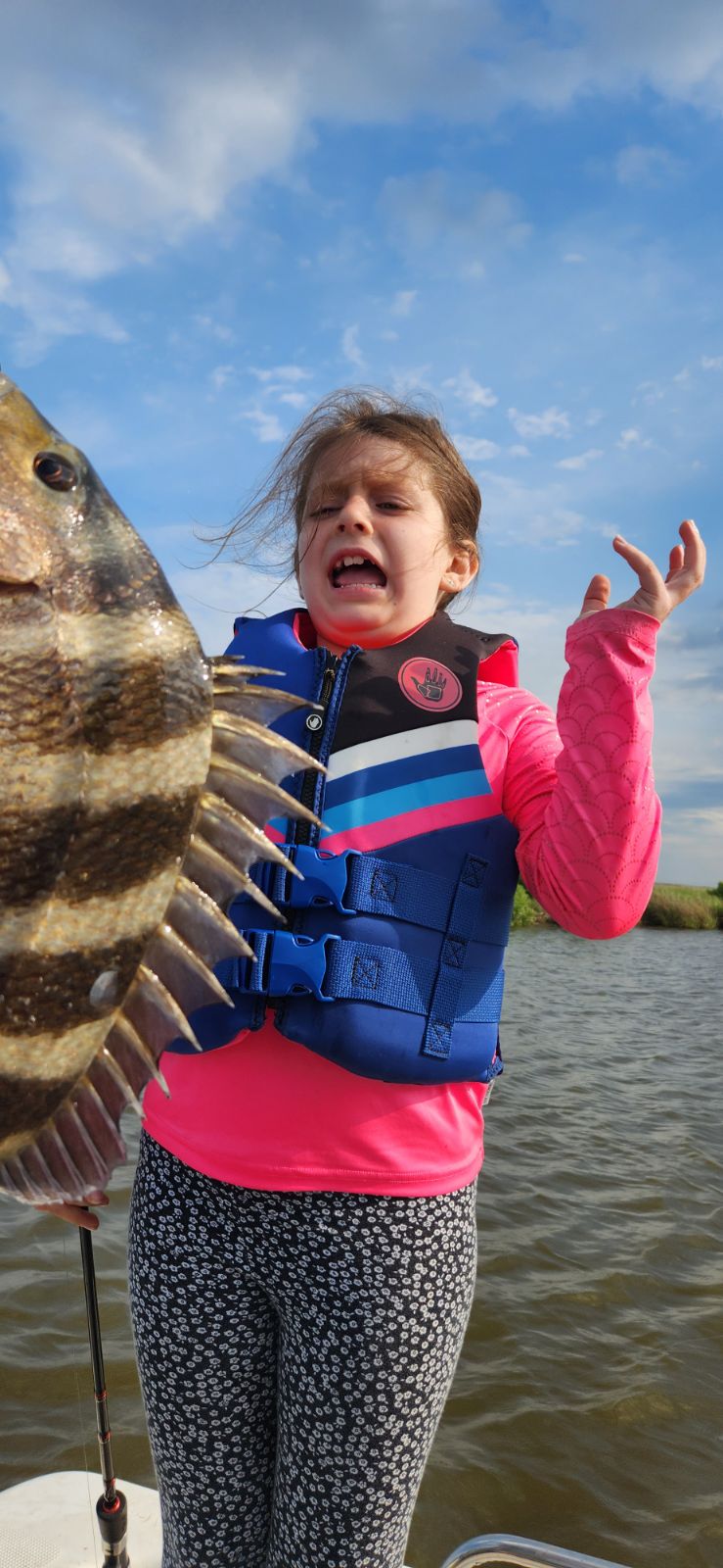 Young BFF member in life jacket reacting with excitement after a surprise catch on the bayou