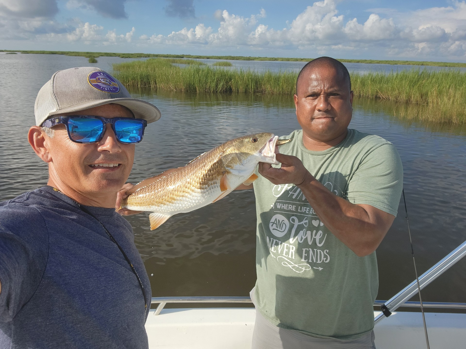 Two BFF members showing off their large redfish catches out on the water