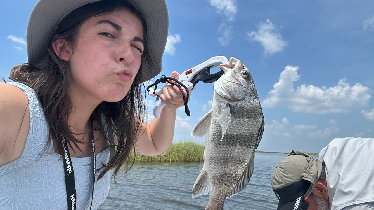 Young BFF member holding up a beautiful speckled trout caught on the Louisiana bayou